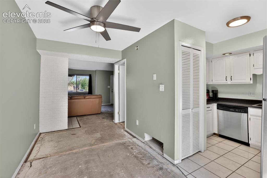 Kitchen area featuring white cabinetry, dark countertops, and stainless steel appliances