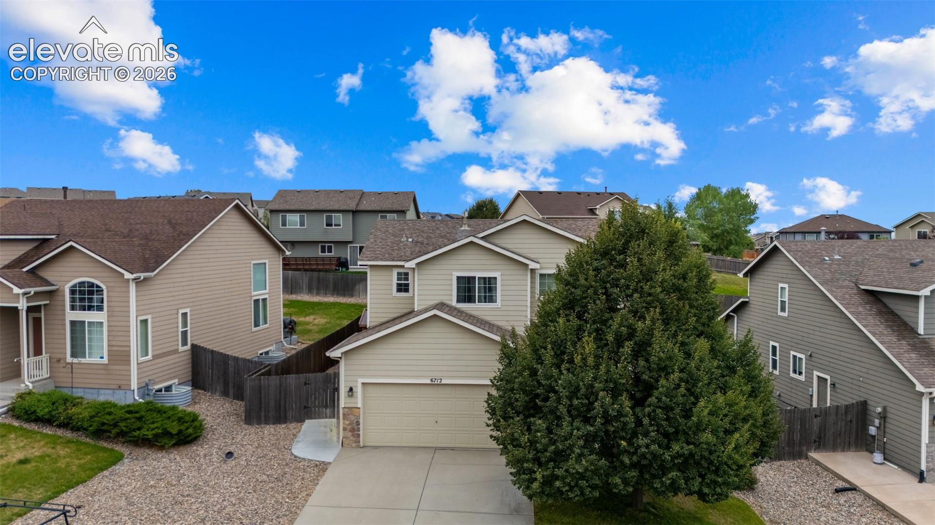 Contemporary two-story residence with attached garage, durable siding exterior, and a paved driveway