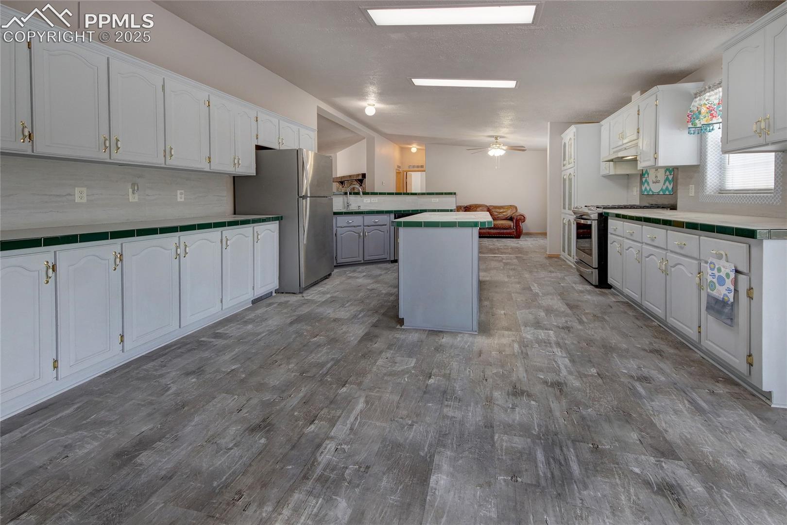 Kitchen featuring lvt floors, spaciousness, and island