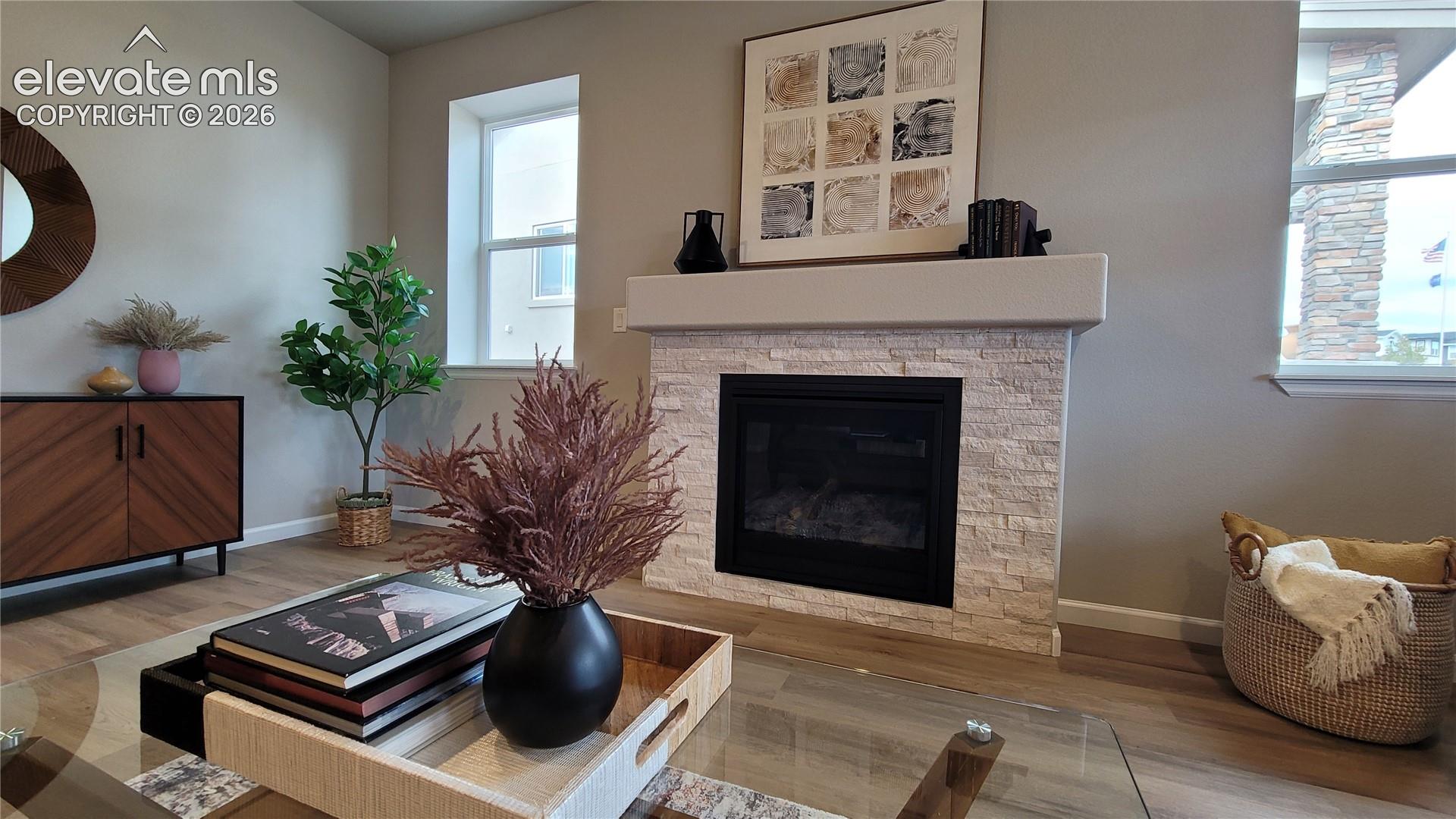 Fireplace featuring a light-toned, textured stacked stone facade and a drywall mantel, complemented by LVP flooring