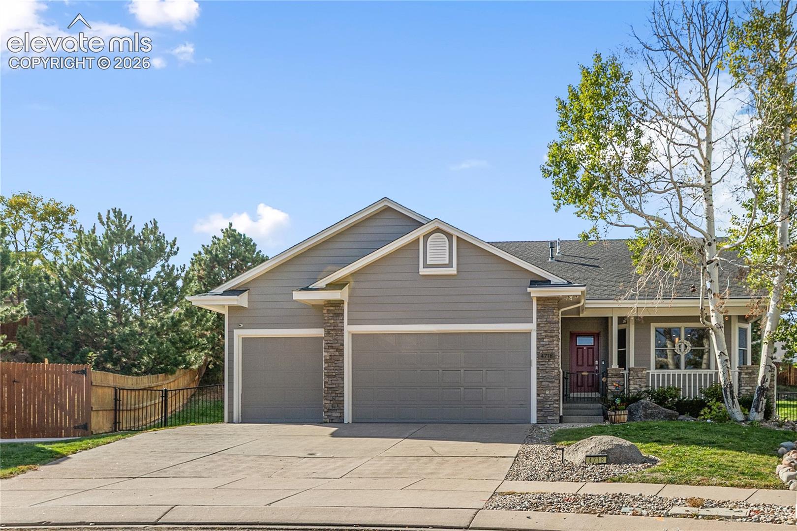 Contemporary exterior with a two-car garage, stone accents, and covered front porch