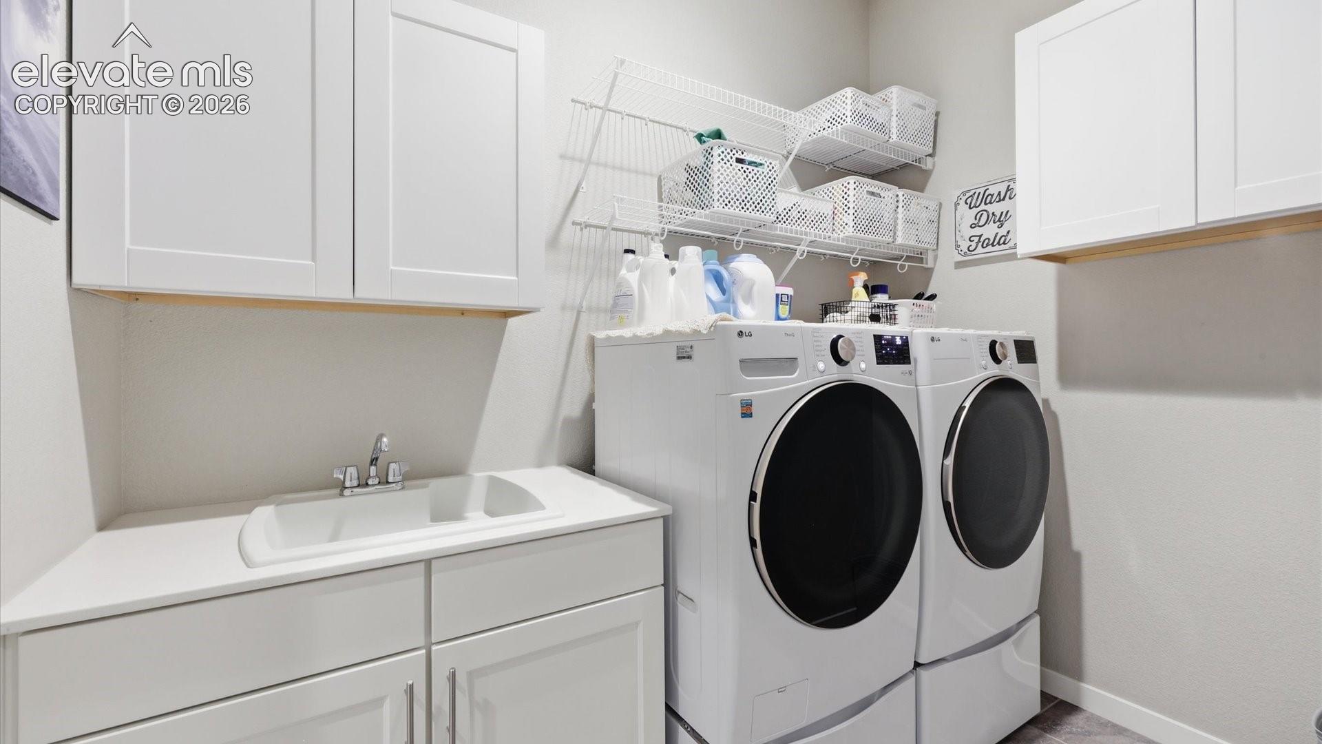 ELEVATED EVERYDAY FUNCTION — A beautifully designed laundry room featuring a utility sink and abundant cabinetry brings exceptional organization, storage, and style to everyday tasks.