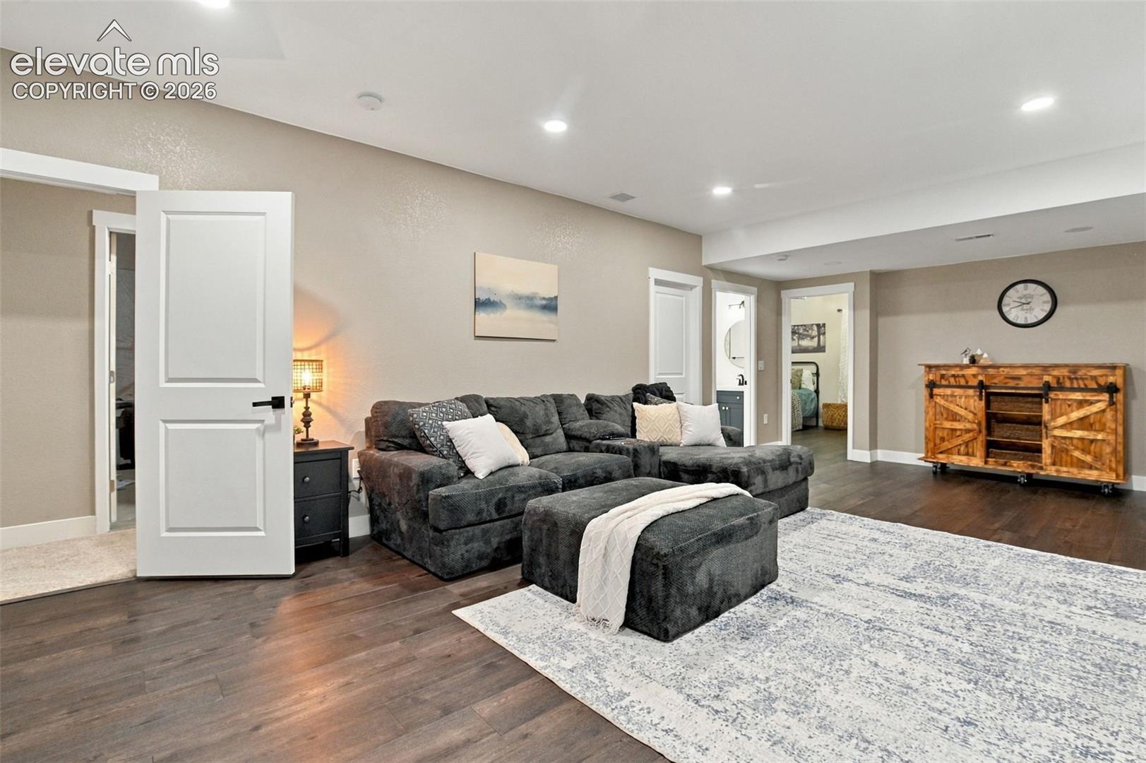Open-concept room featuring wood-finish flooring, recessed lighting, and multi-panel interior doors with matte black hardware