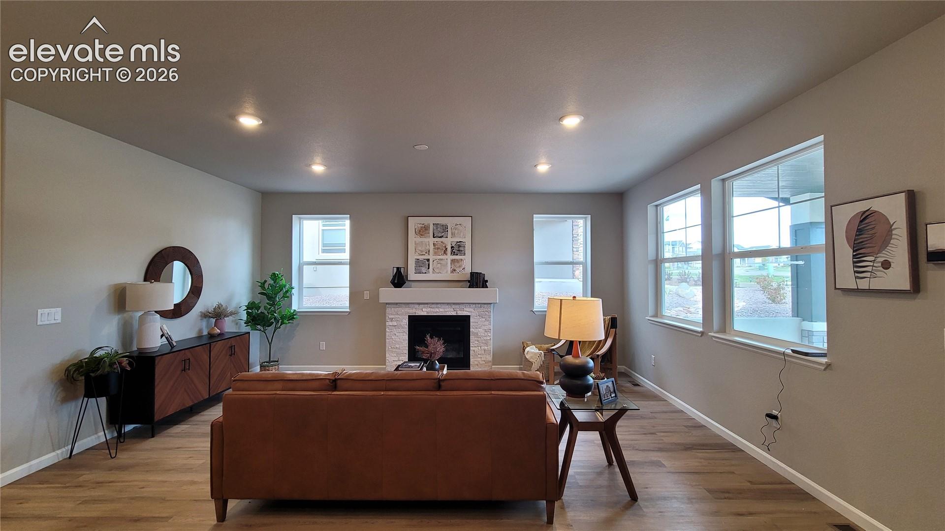 Living area featuring recessed lighting, LVP flooring, and a stacked stone fireplace!