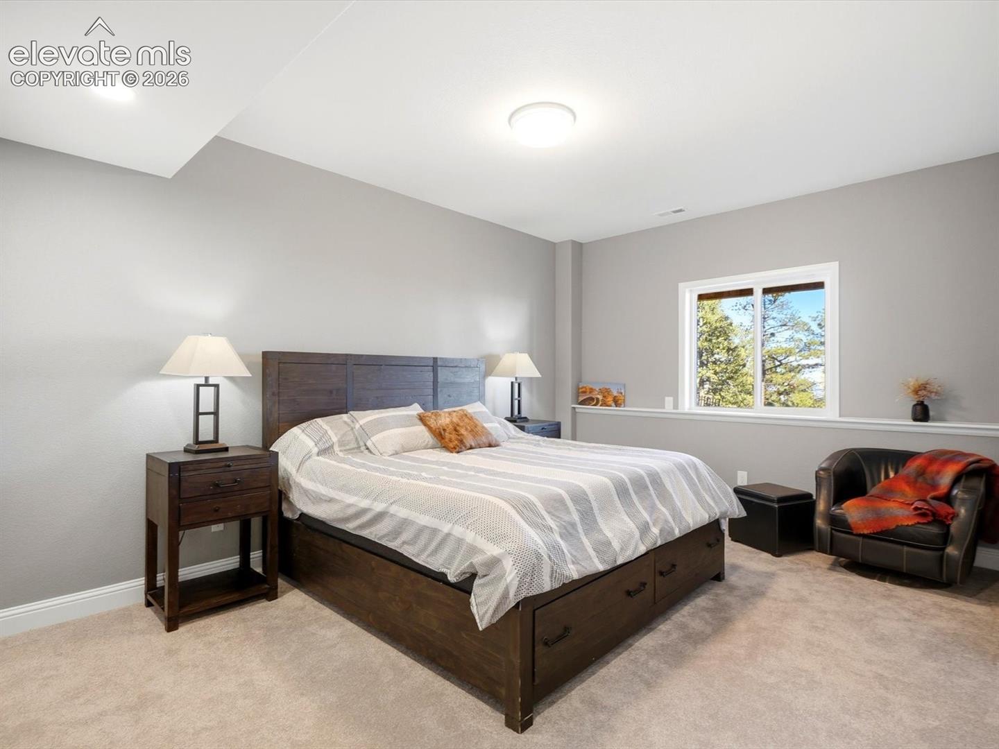 Basement Bedroom Neutral-toned interior featuring wall-to-wall carpeting, recessed lighting, flush-mount ceiling lighting, and a wide window with exterior scenery
