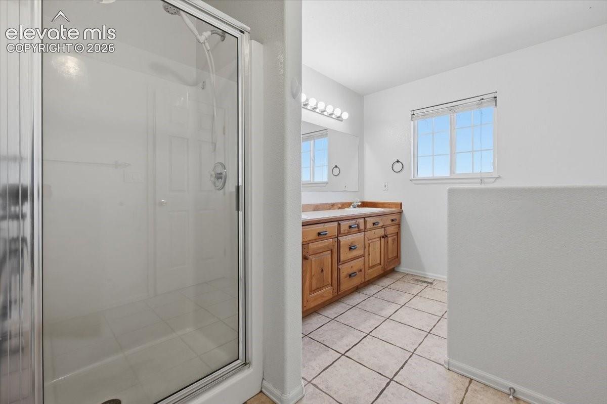 Glass-enclosed shower with a chrome fixture