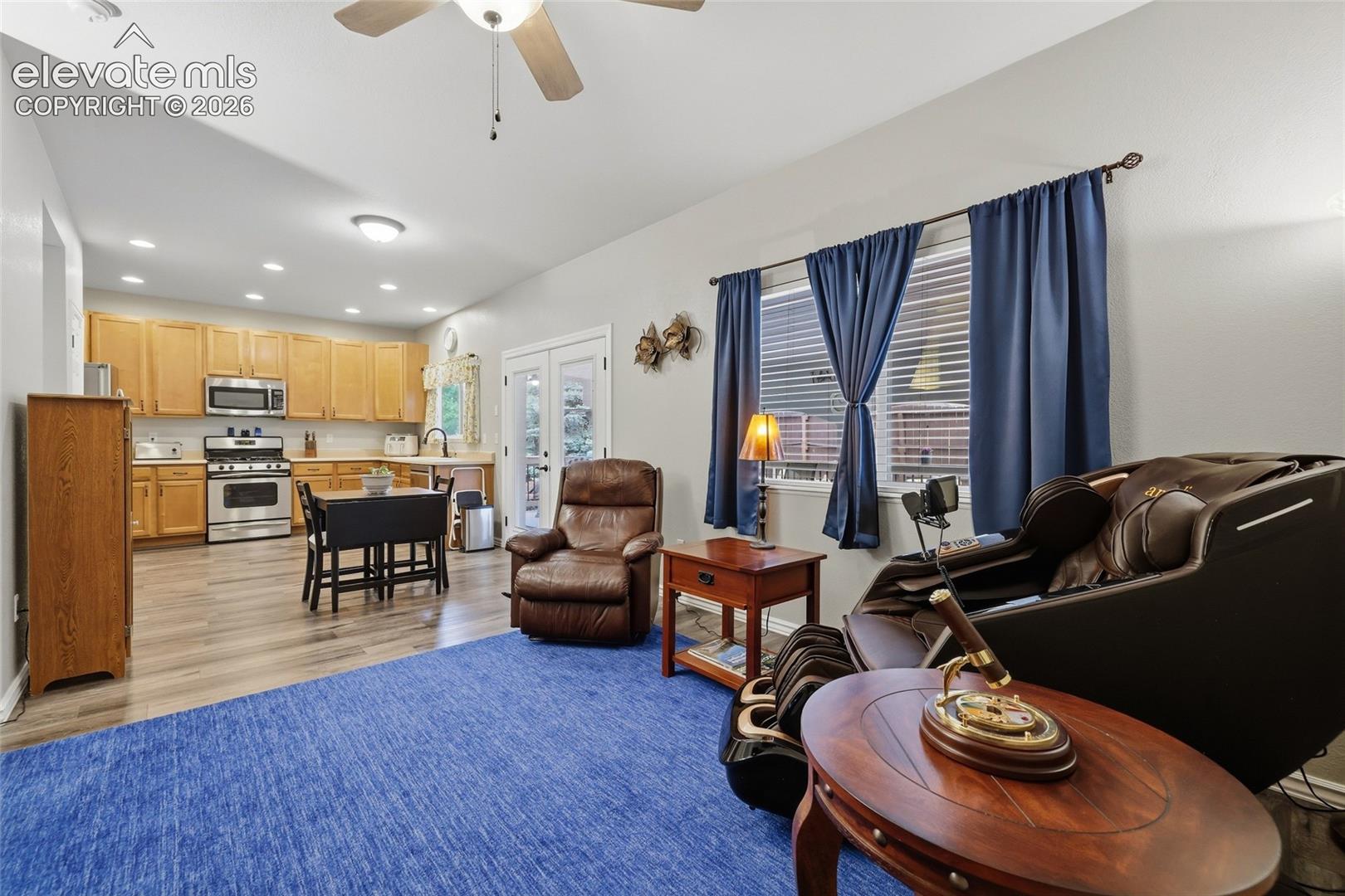Living area featuring LVP flooring, a ceiling fan, gas fireplace, and built-ins 