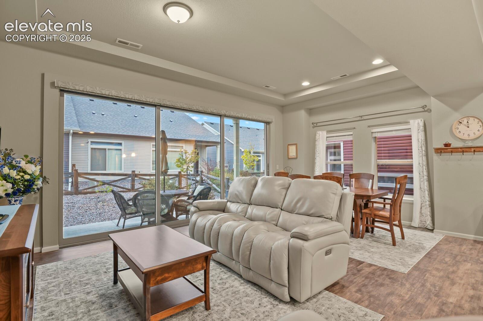 Tray ceilings with recessed lighting, 17' wide sliding glass doors, and wood-finish luxury tile flooring