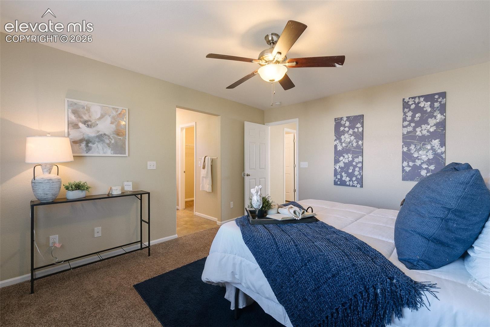 Neutral wall paint, plush carpeting, and a ceiling-mounted light fixture with integrated fan