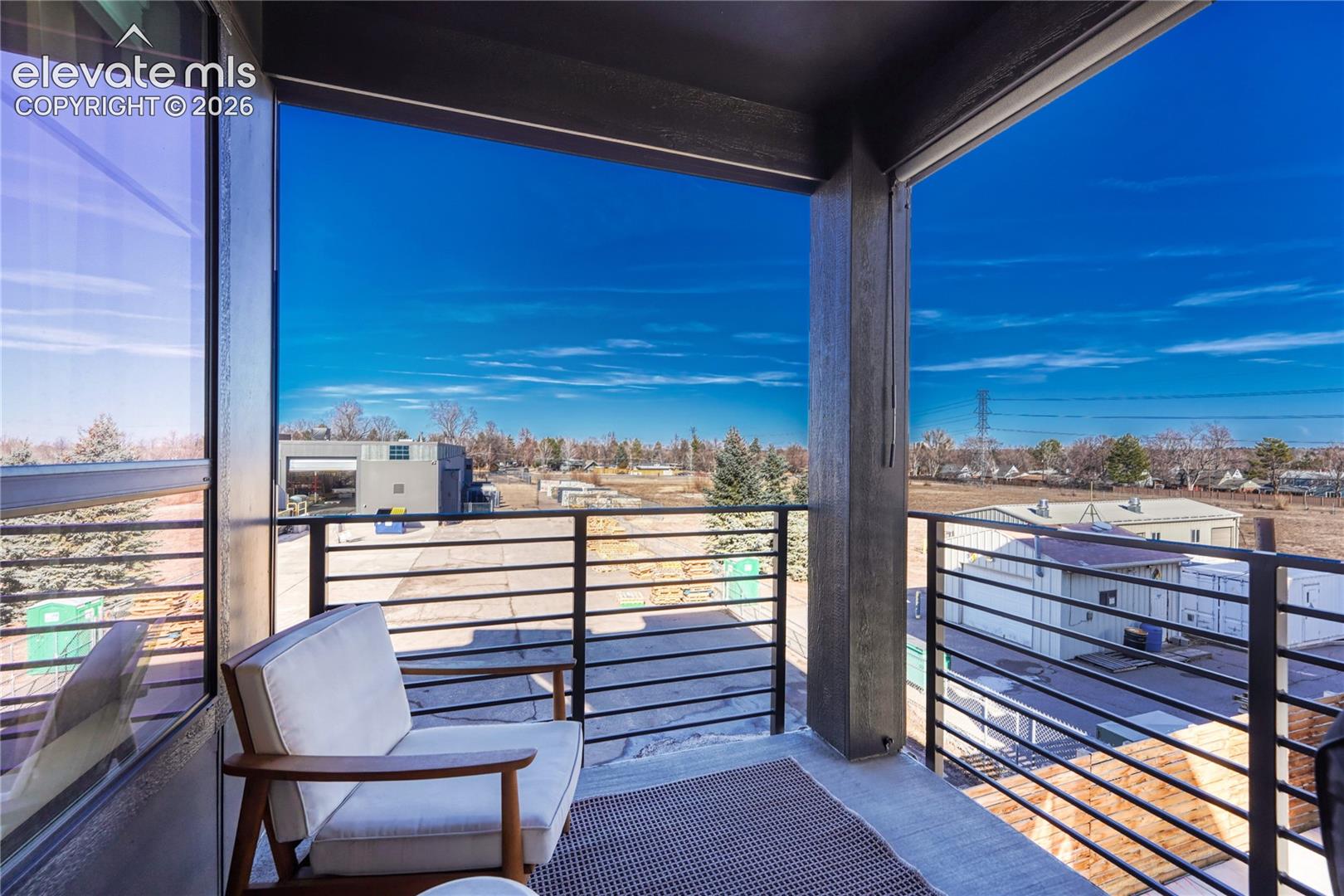 Covered balcony featuring concrete flooring and horizontal metal railing
