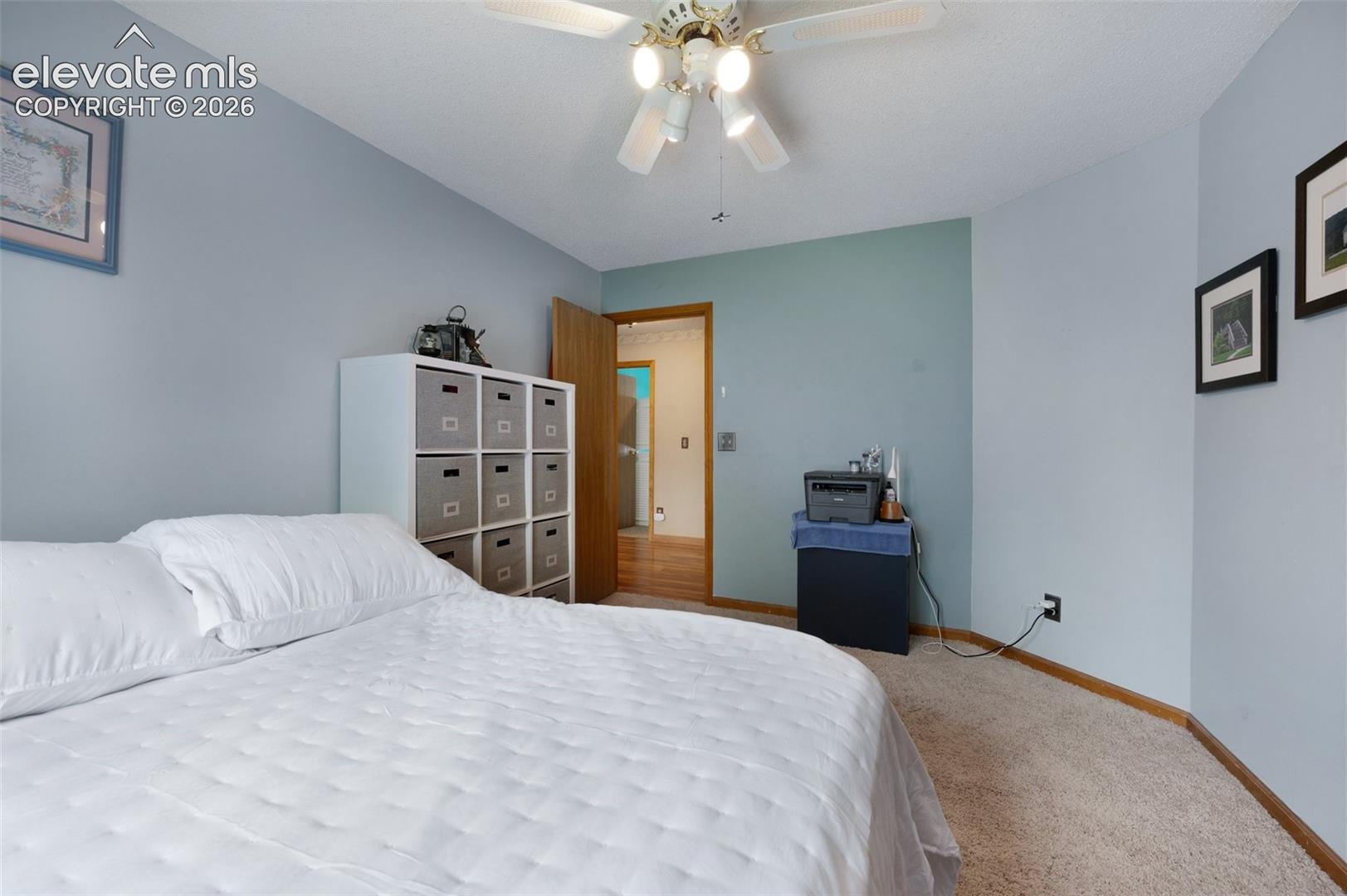 Carpeted bedroom featuring baseboards and a ceiling fan