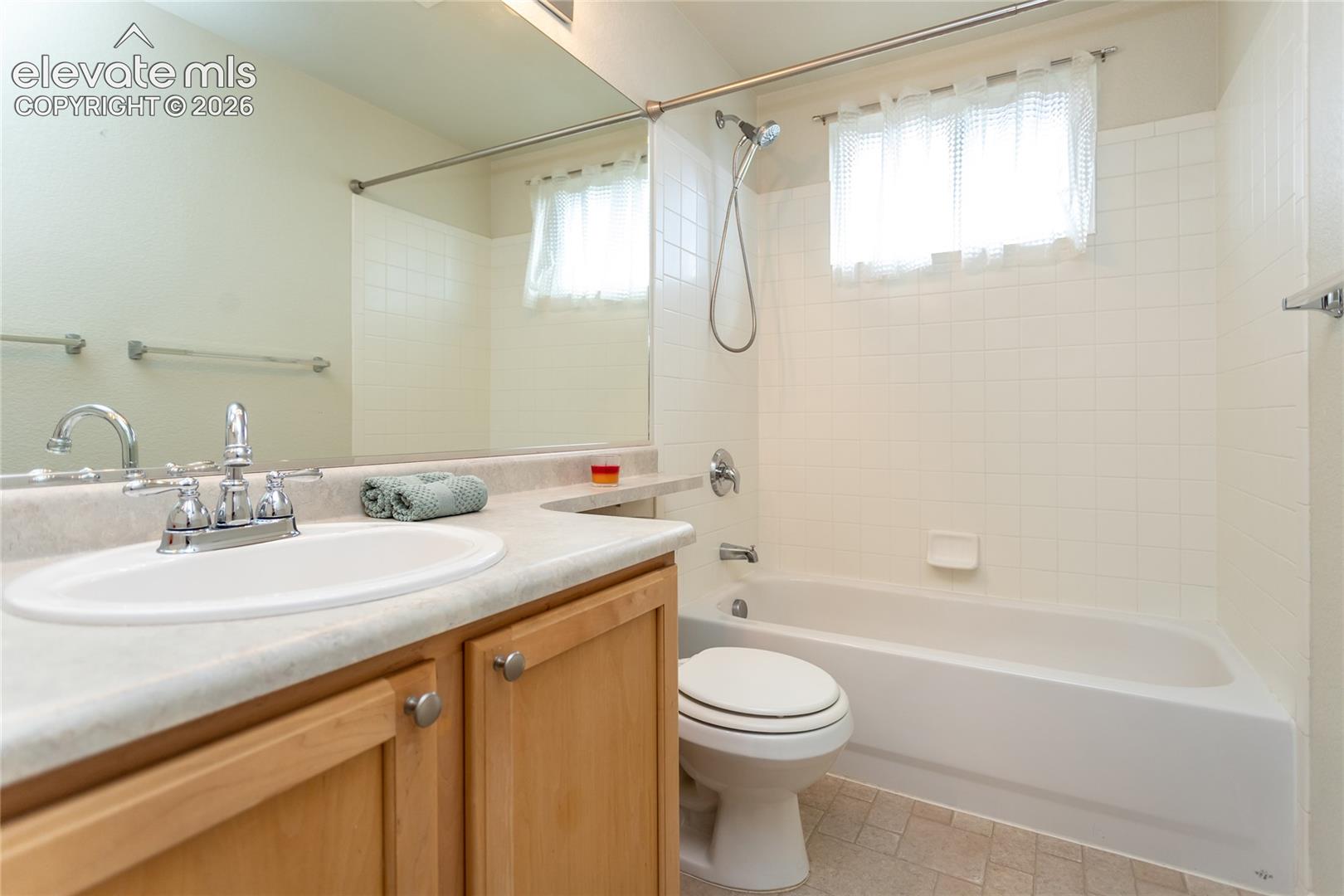 Upper level full bathroom with laminate countertops and flooring. Shower-tub combo.