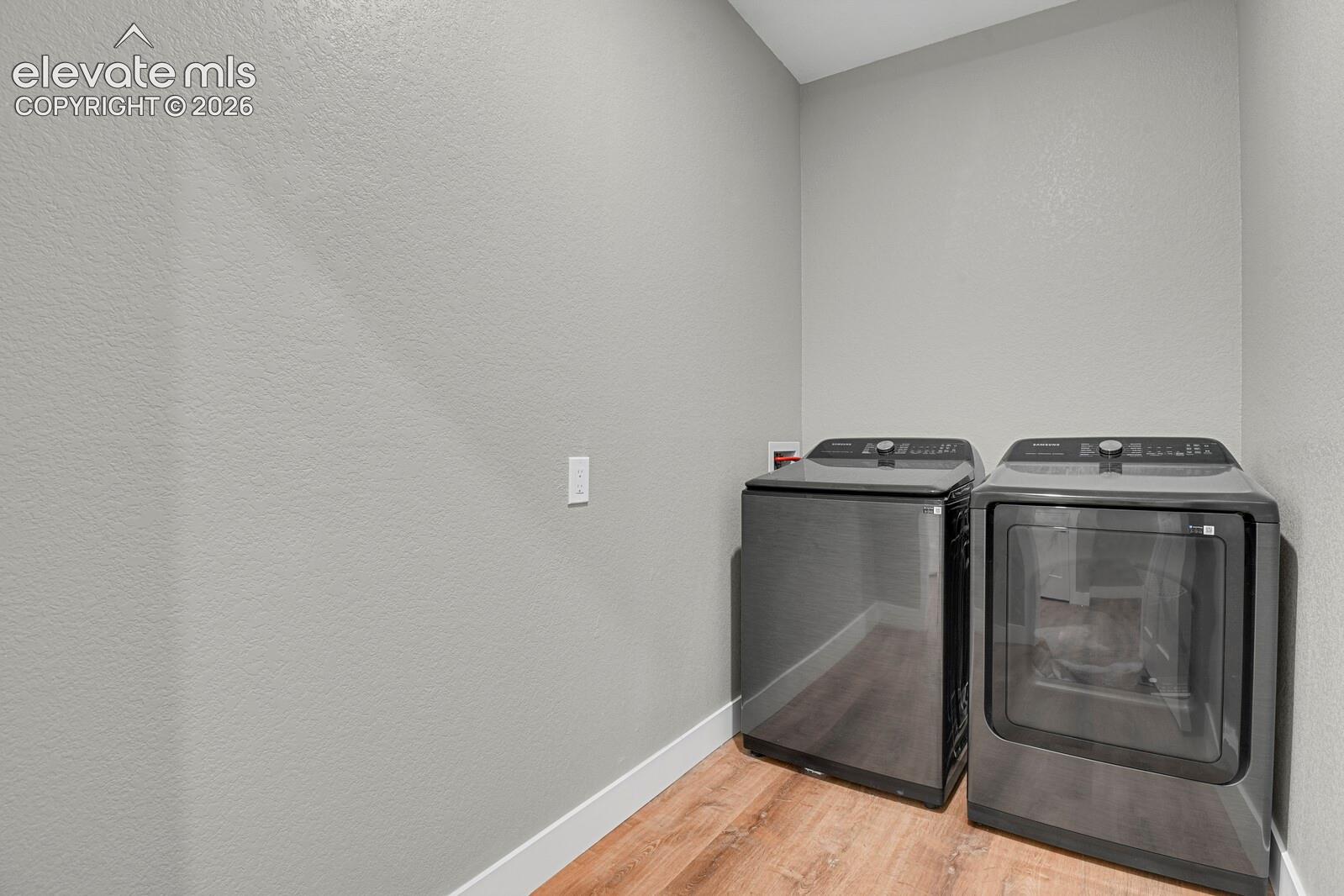Utility area featuring wood-finish flooring and neutral-toned wall paint