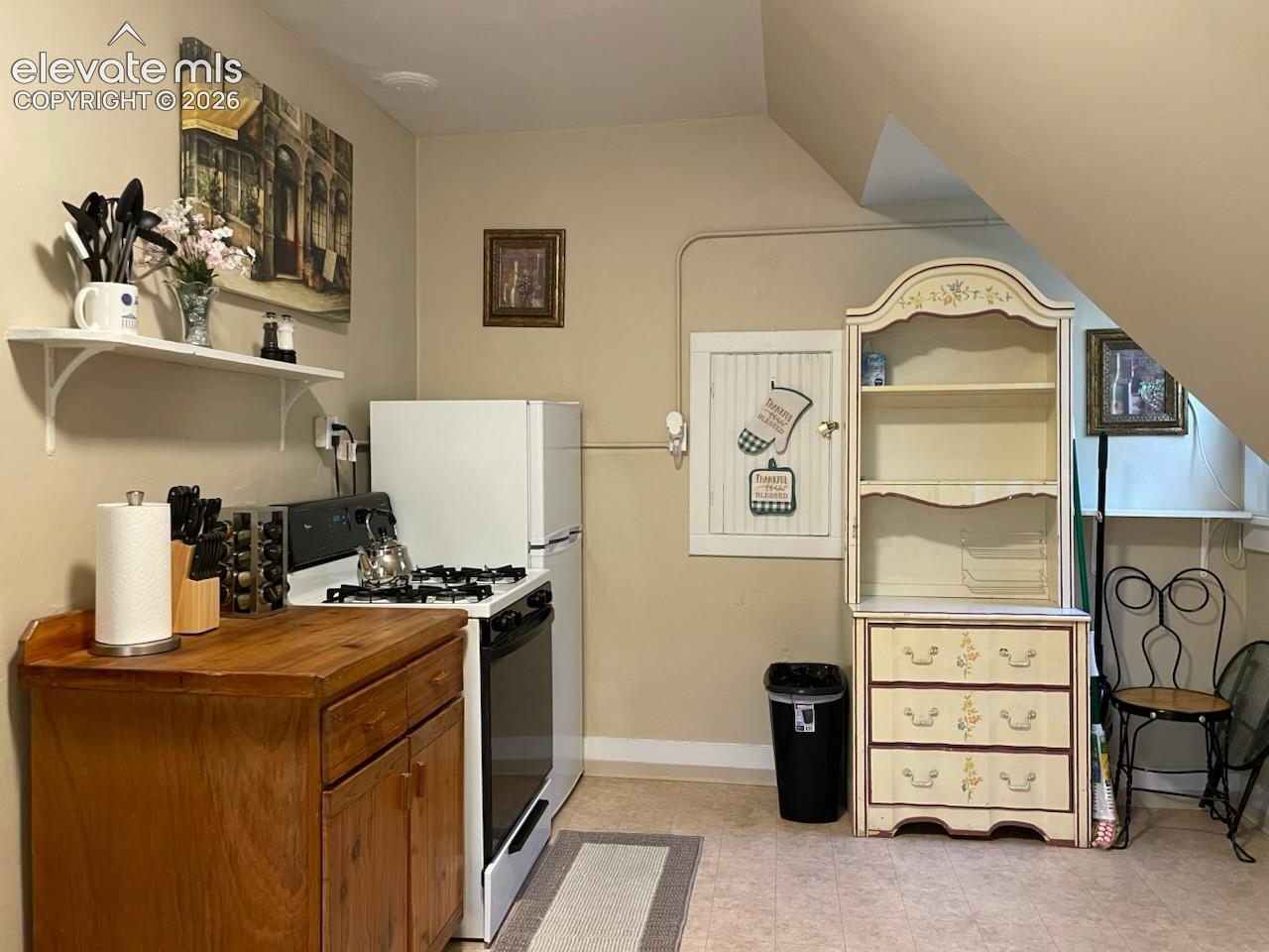 Compact kitchen space with a gas range and a full-size refrigerator