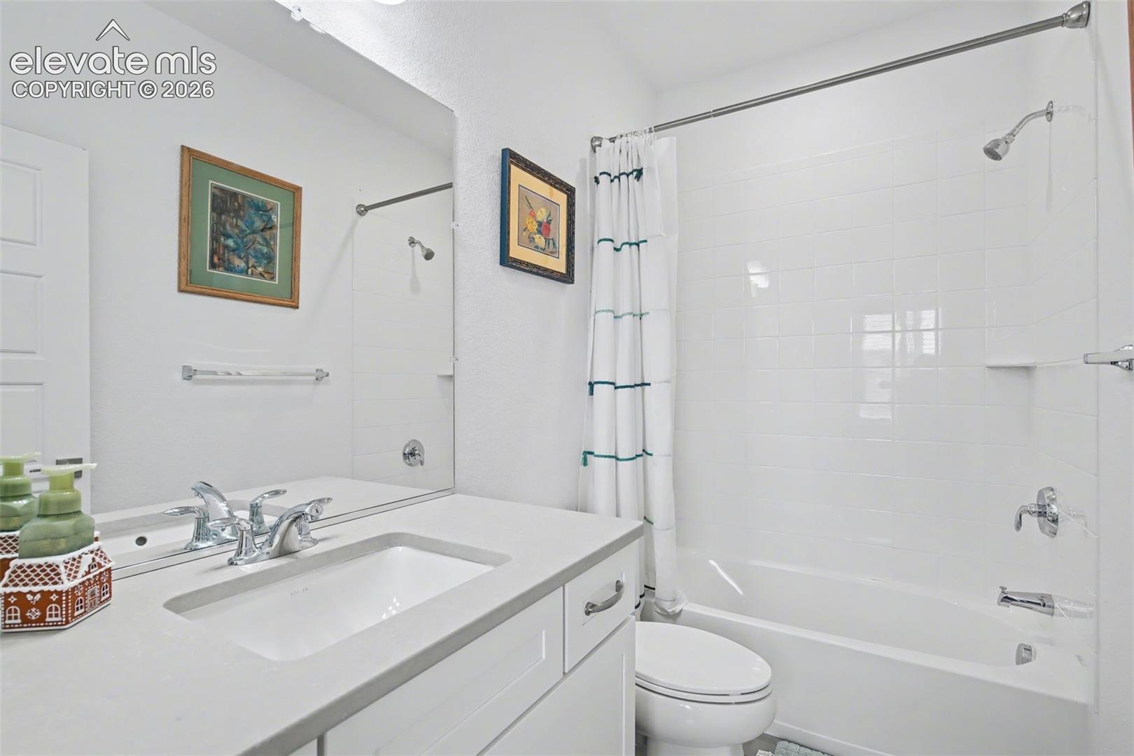 Bathroom featuring vanity and shower / tub combo with curtain