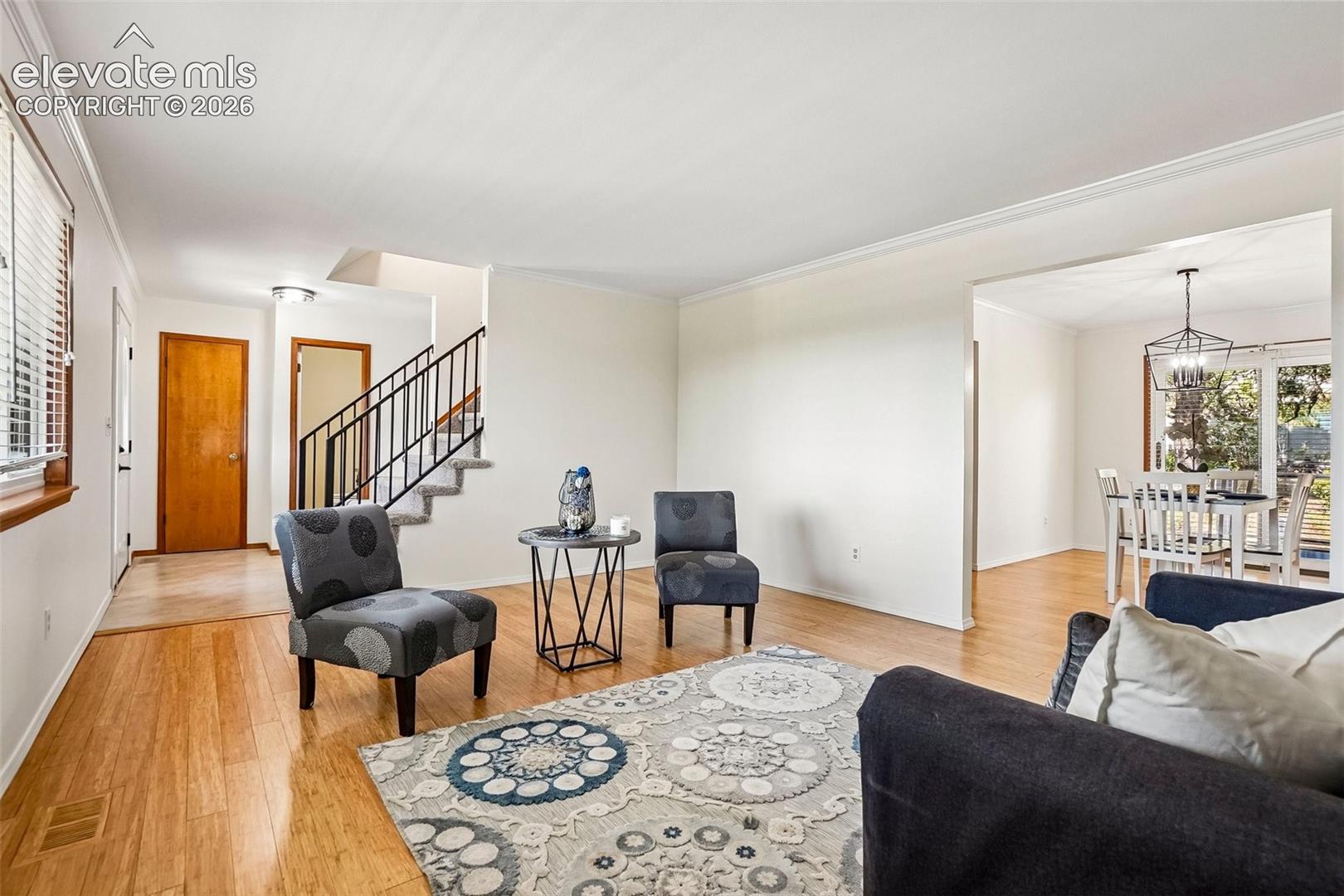 Living room is bathed in natural light and open to formal dining space.