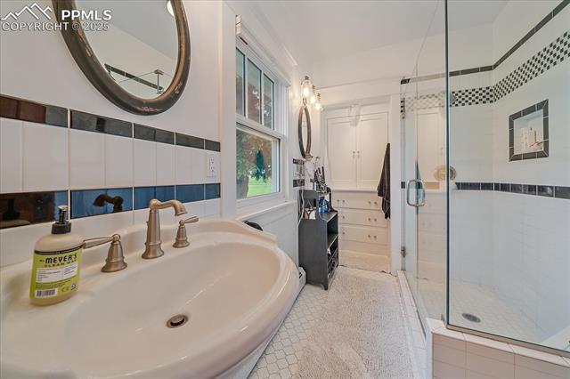 Full bath featuring a stall shower and a sink