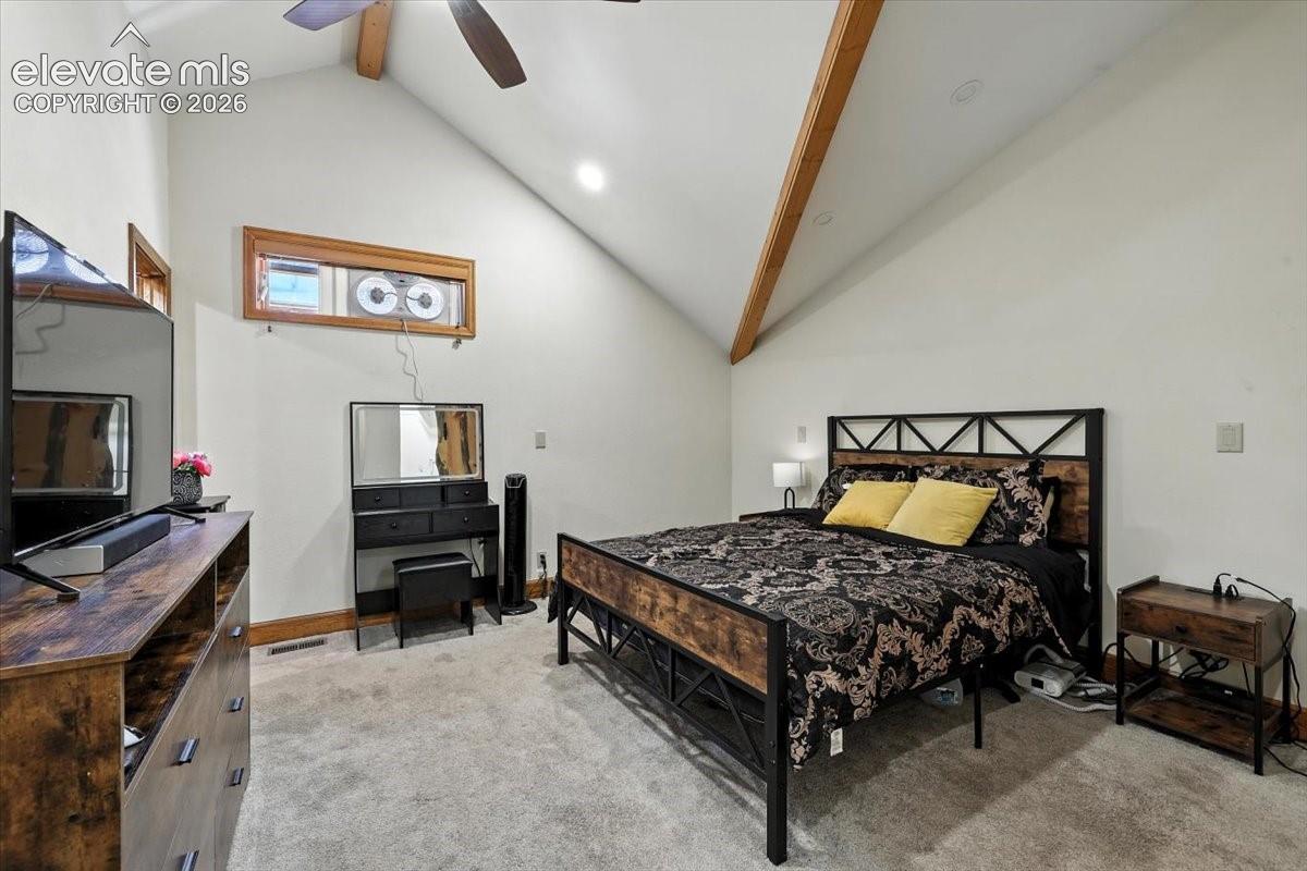 Vaulted ceilings with exposed wooden rafters, recessed lighting, ceiling fan, and carpeted flooring