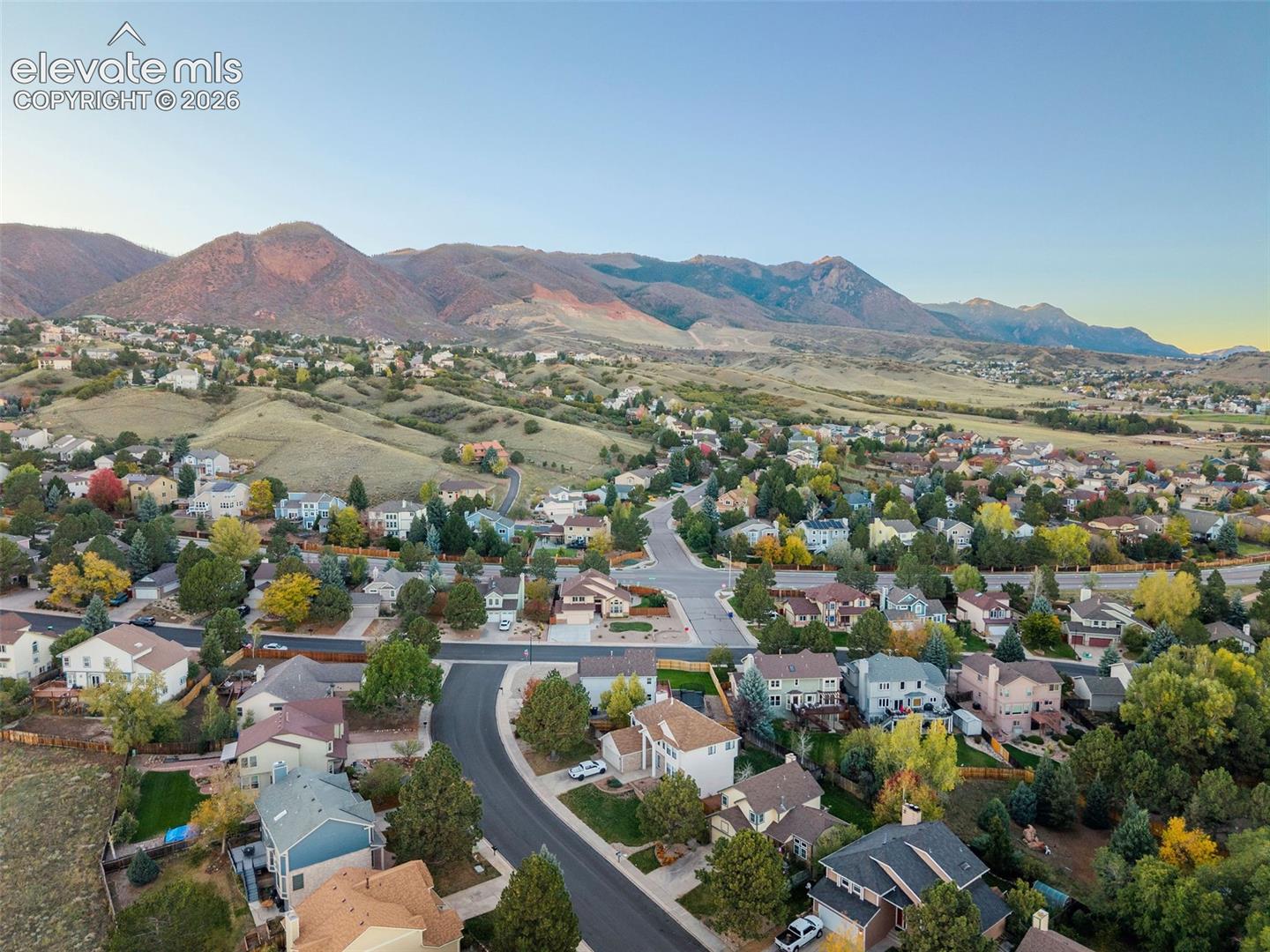 Aerial perspective of residential neighborhood featuring paved streets and mountain backdrop