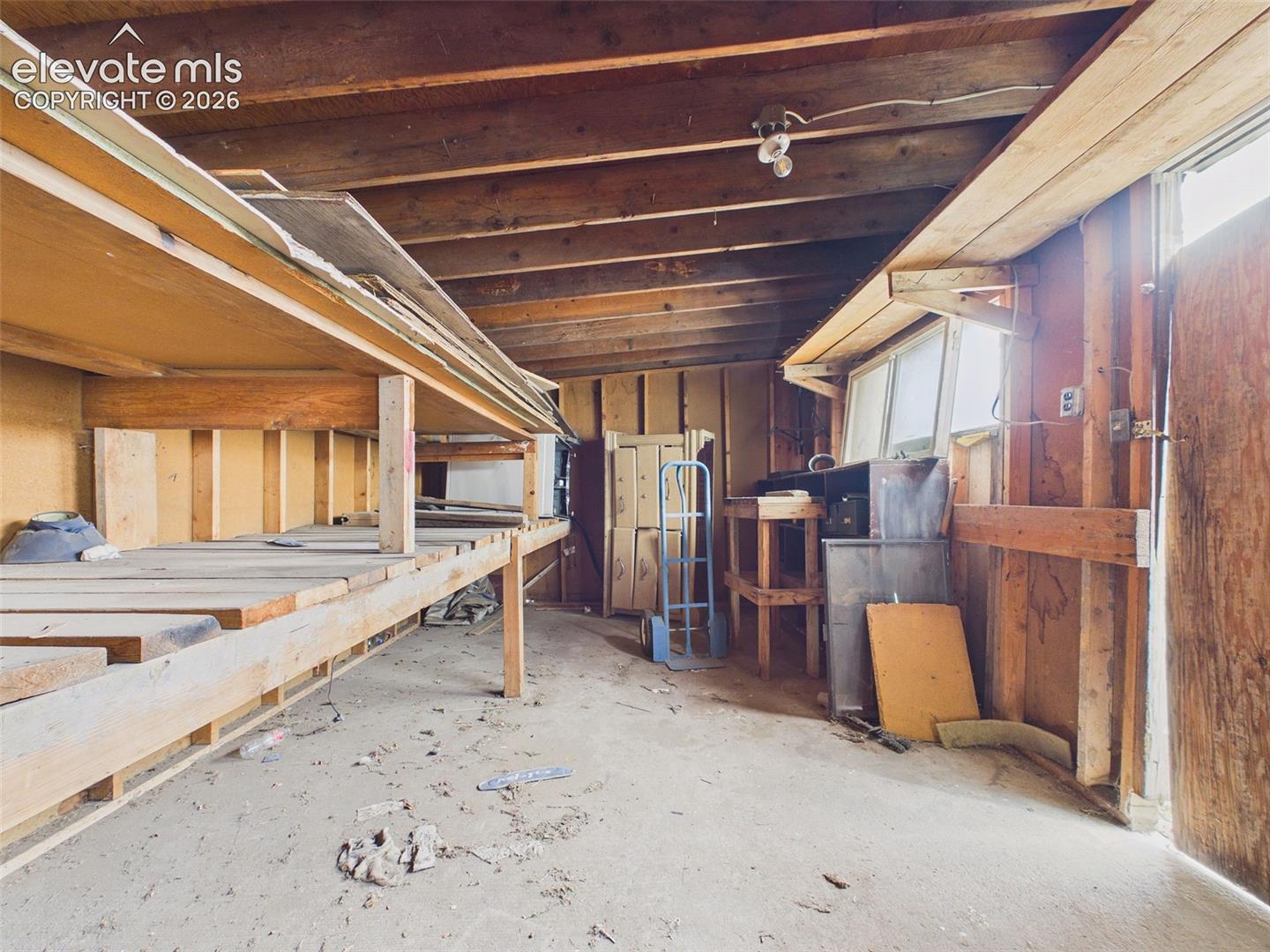 Additional workshop interior showcasing extensive wooden shelving, exposed framing, and flexible storage space for tools, supplies, and equipment.