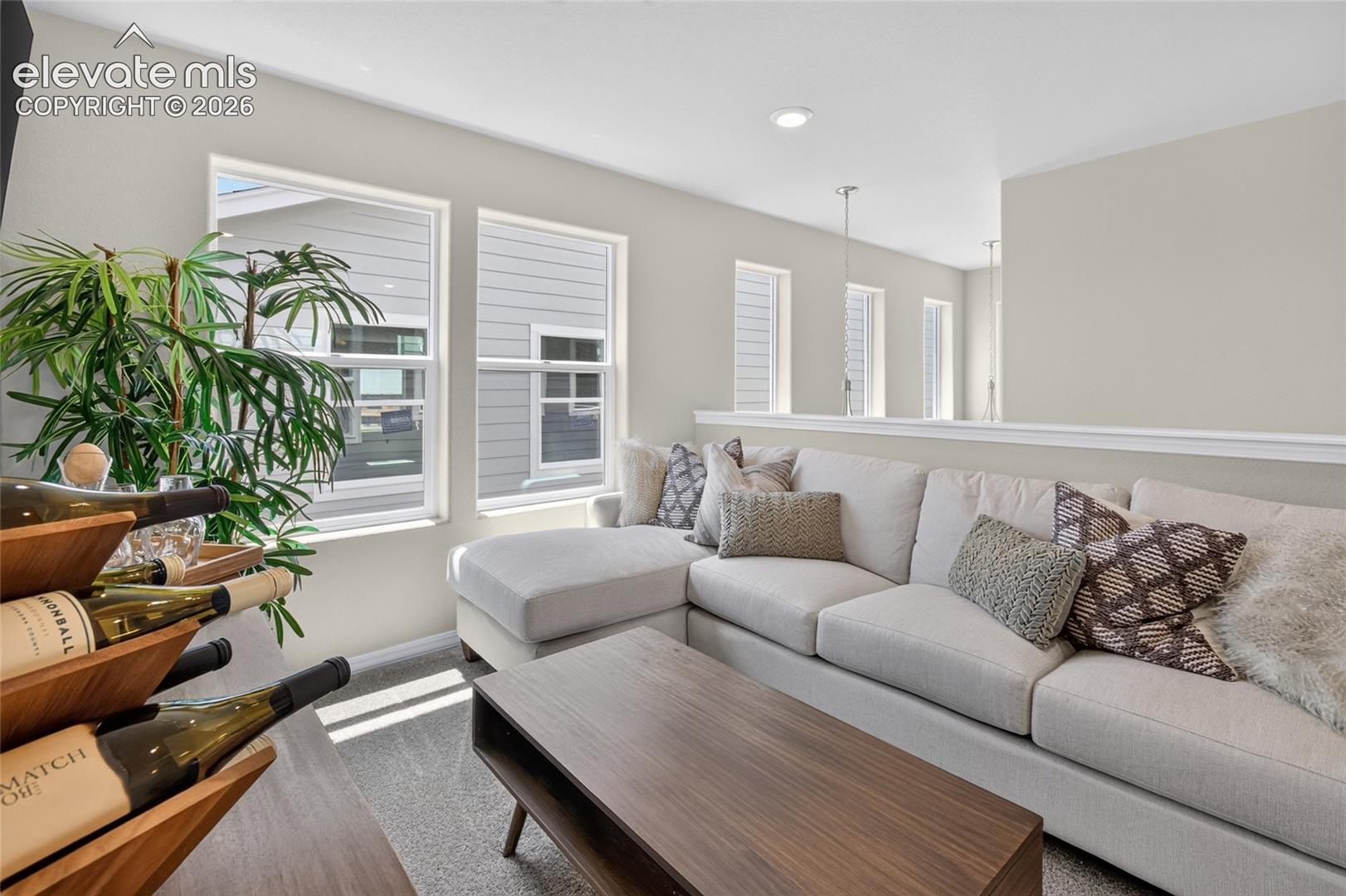 Neutral interior featuring multiple large windows, recessed lighting, and carpeted flooring