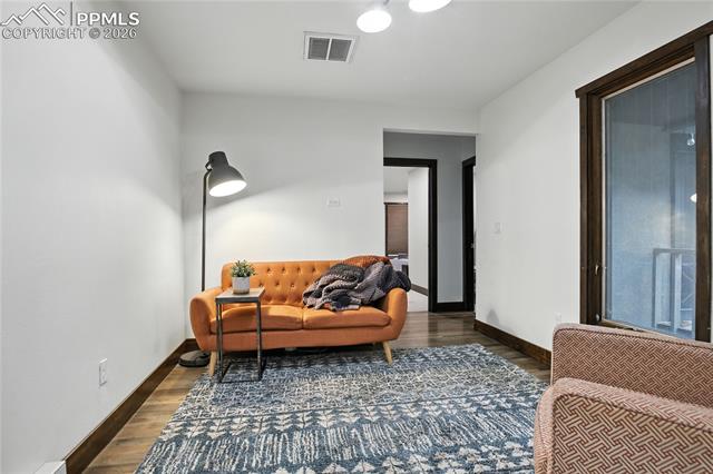 Living area featuring dark wood-style flooring and baseboards