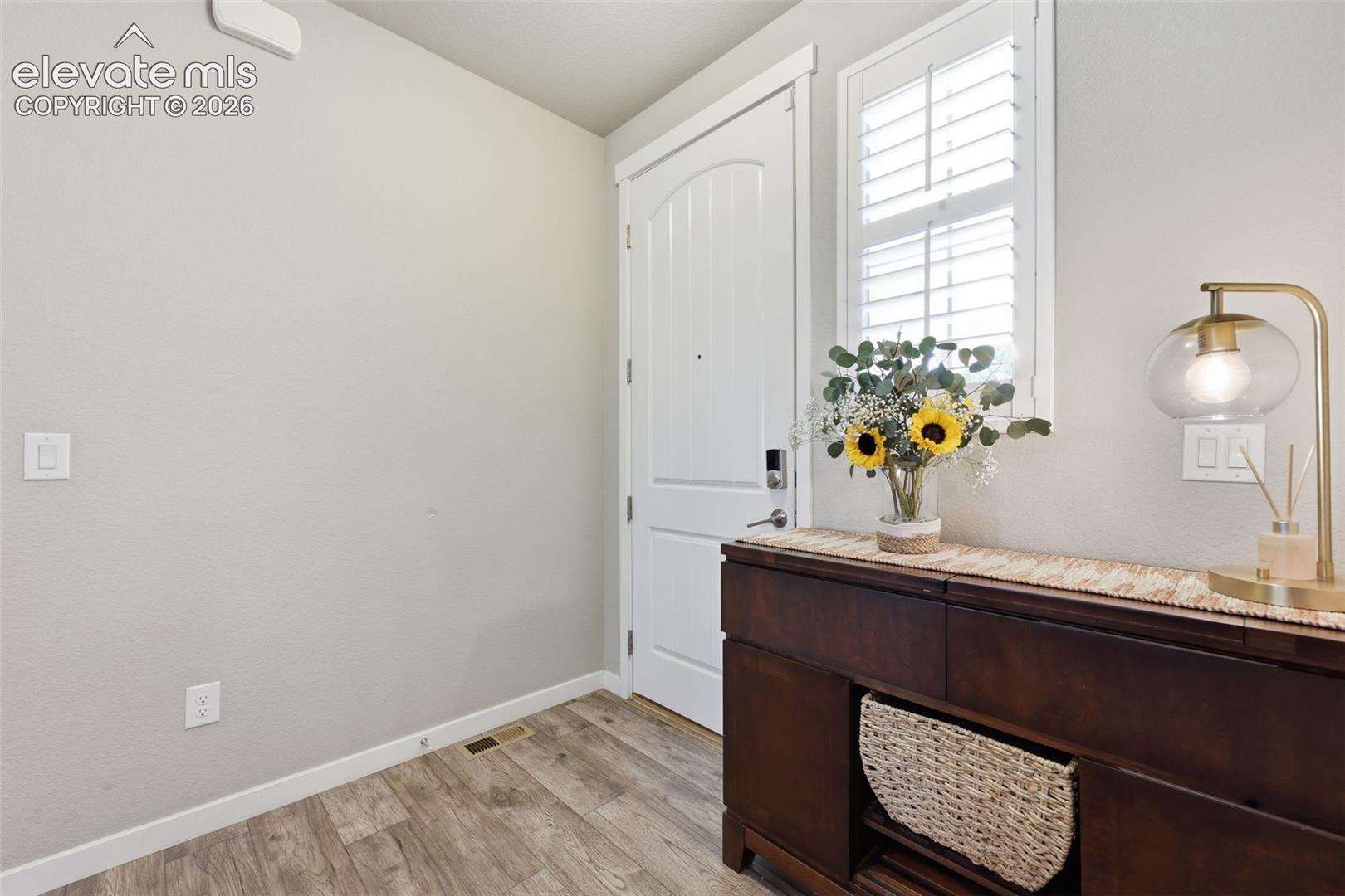 Entry featuring light brown luxury vinyl plank flooring throughout the main level.