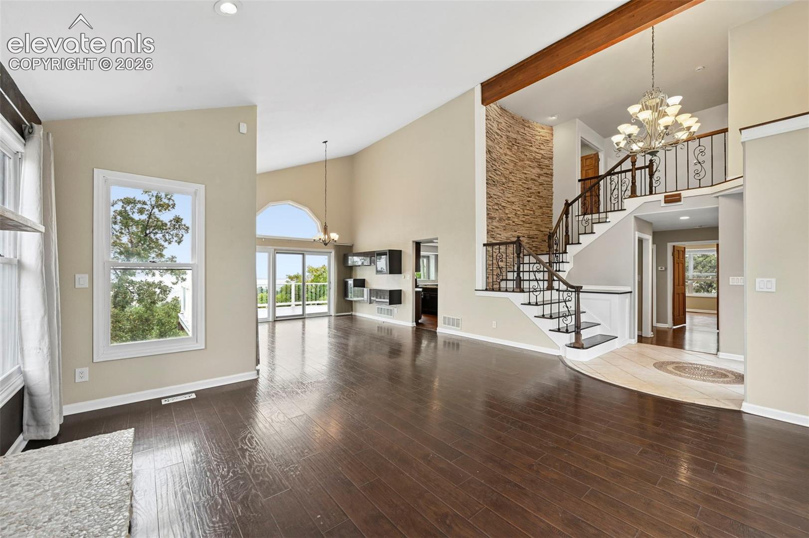 Looking across the formal living room with stone fireplace into the formal dining room