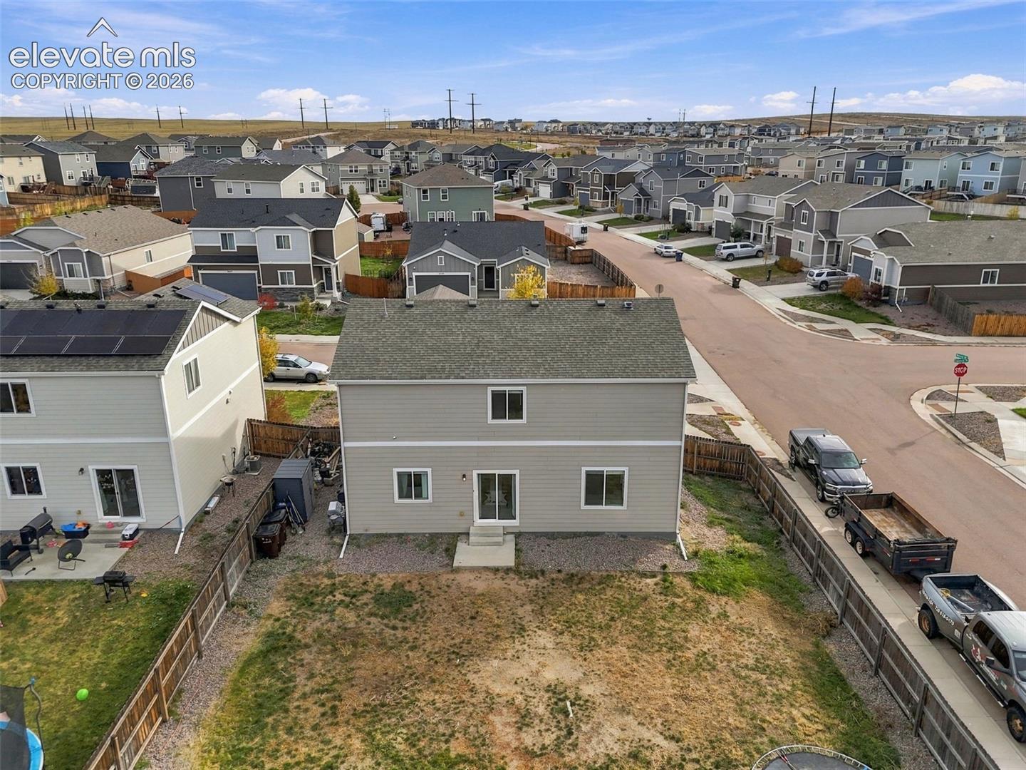 Two-story residence featuring horizontal siding, asphalt shingle roof, sliding glass door, and a fenced rear yard