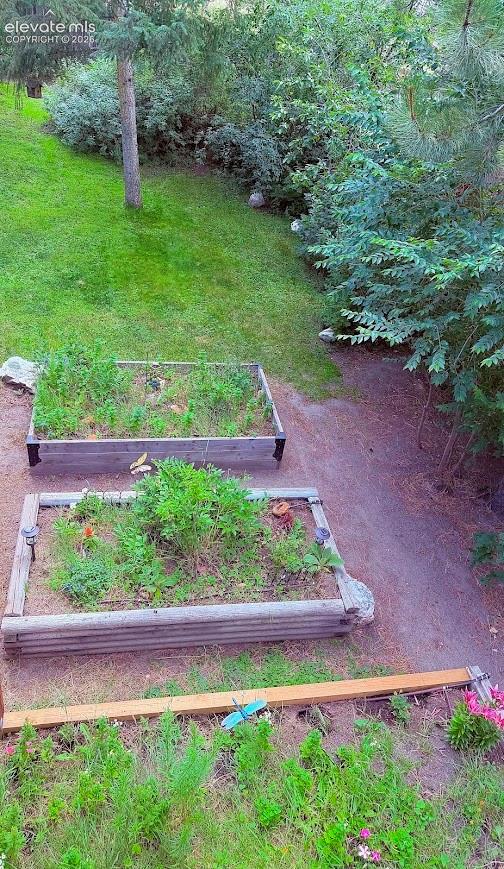Landscaped exterior featuring two wooden raised garden beds, a gravel path, and natural stone accents