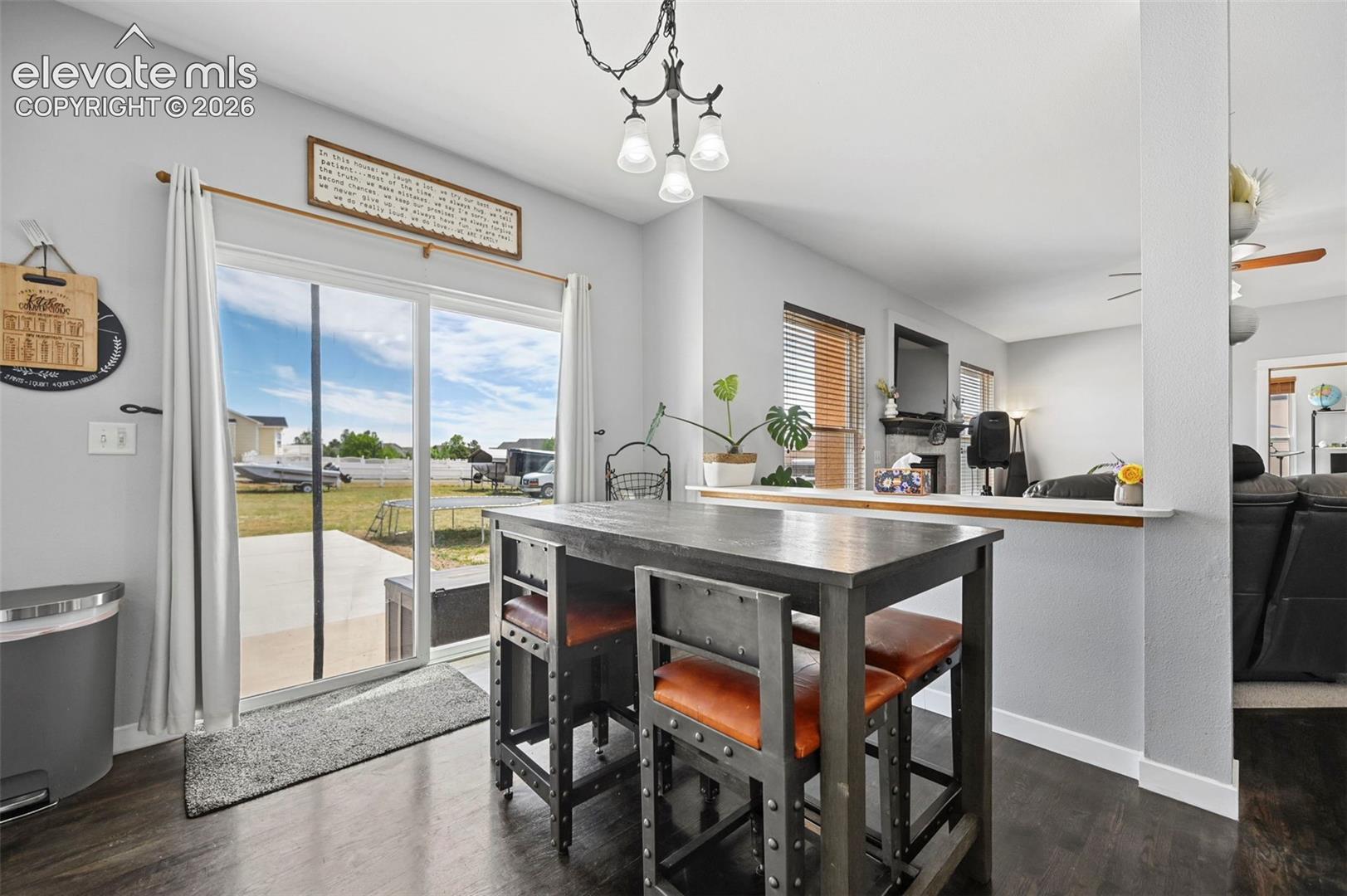 Dining area featuring dark wood-finish flooring and a contemporary pendant light fixture