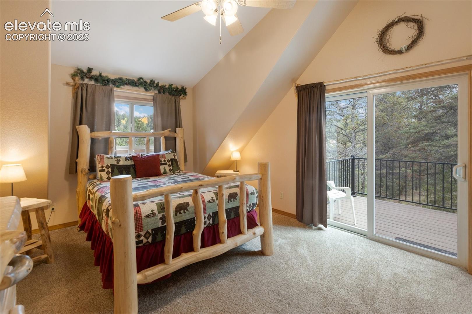 Carpeted room with a ceiling fan, a window, and a sliding glass door opening to a deck with black railings