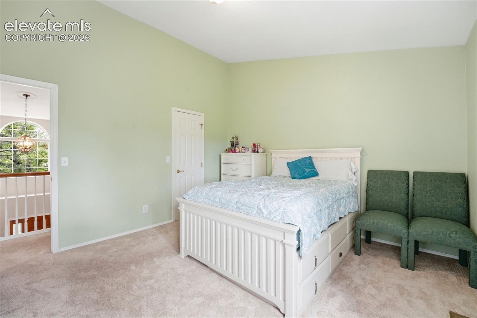 Carpeted room featuring a vaulted ceiling and light green walls