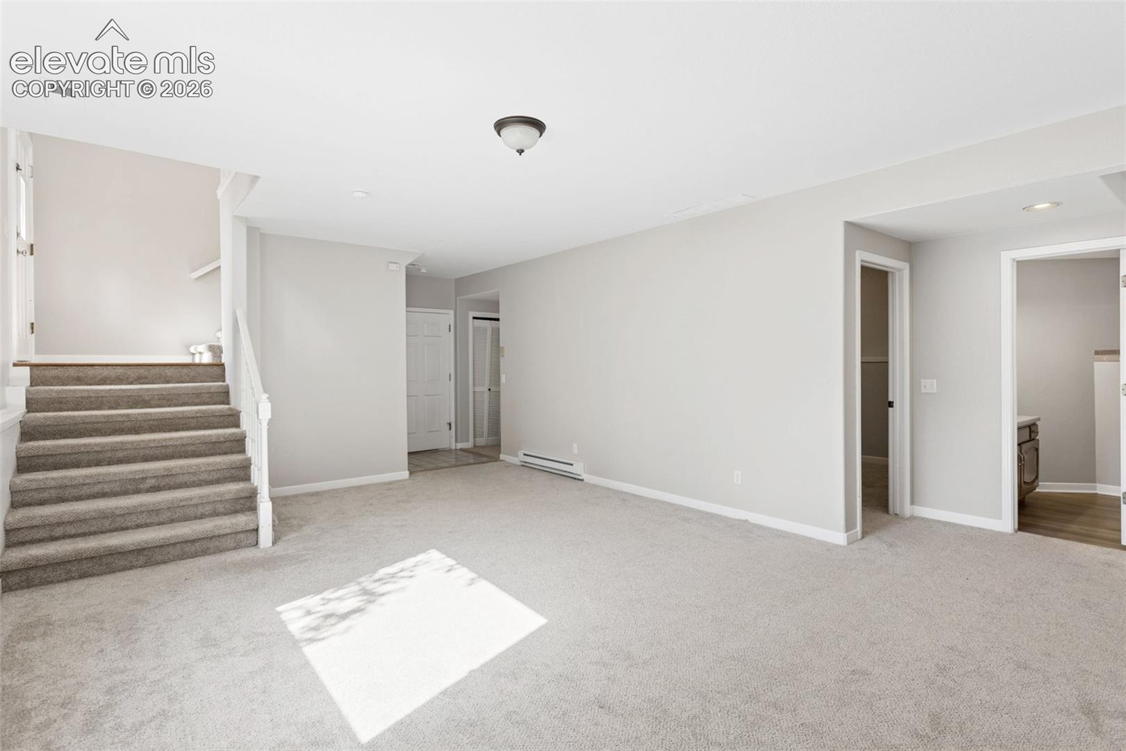 Expansive room with neutral carpeting and light gray wall tones