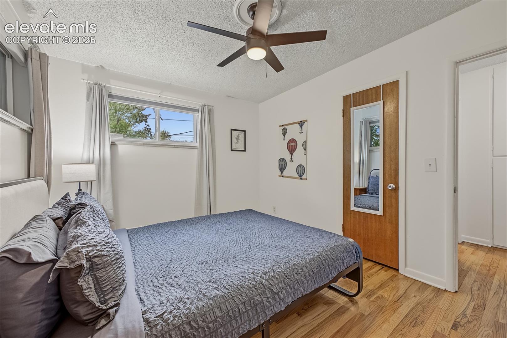 Wood-finish flooring, ceiling fan with light fixture, and horizontal sliding window