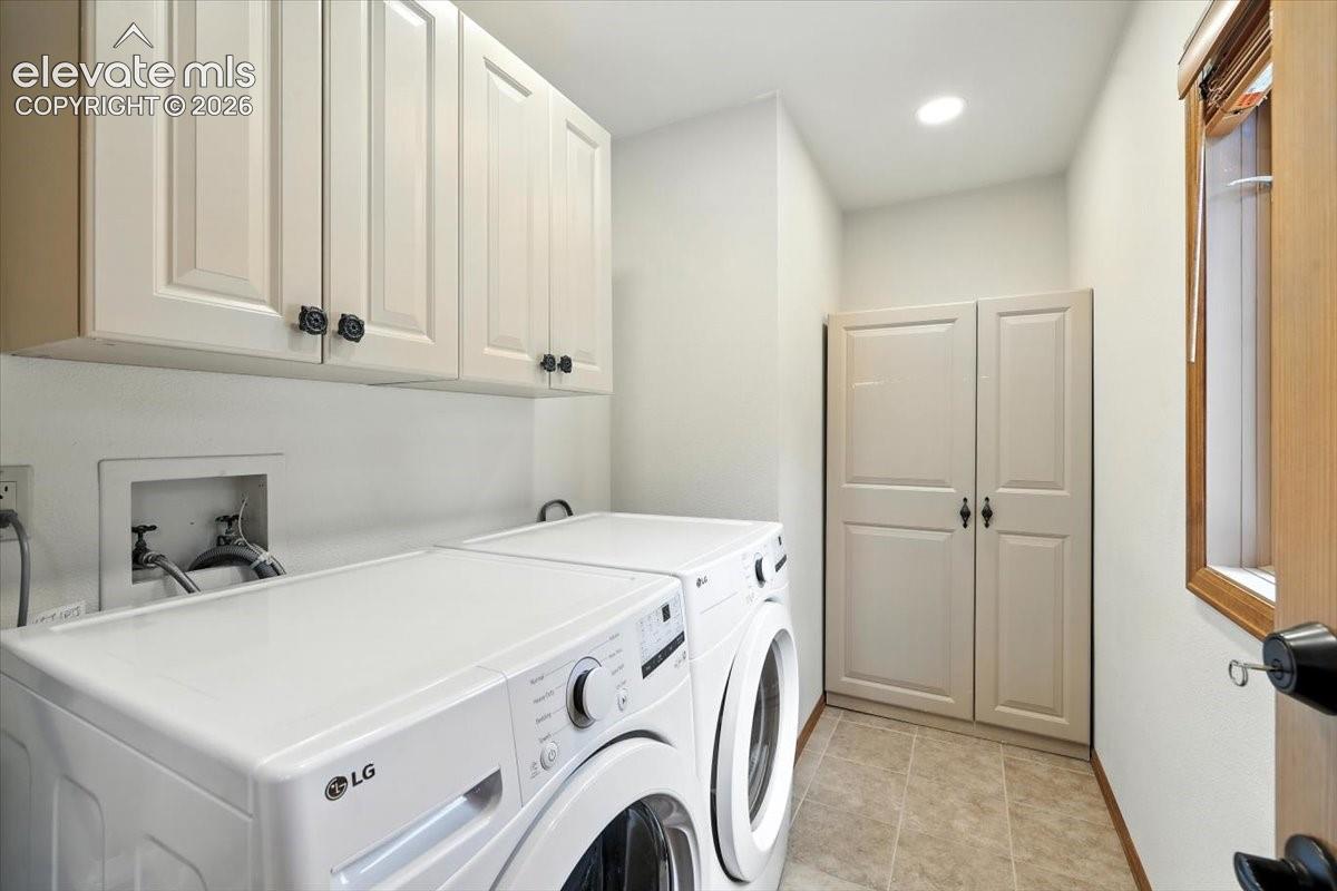 Laundry room featuring off-white cabinetry, full-height built-in storage closet, recessed lighting, and tile flooring