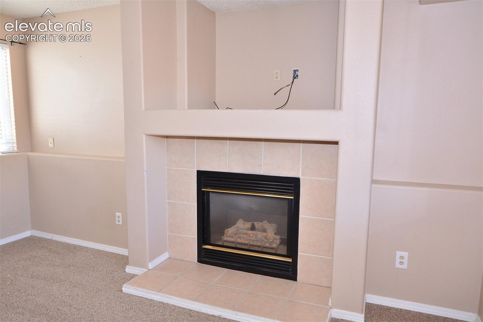 Built-in fireplace with tile surround, raised hearth, and integrated media niche