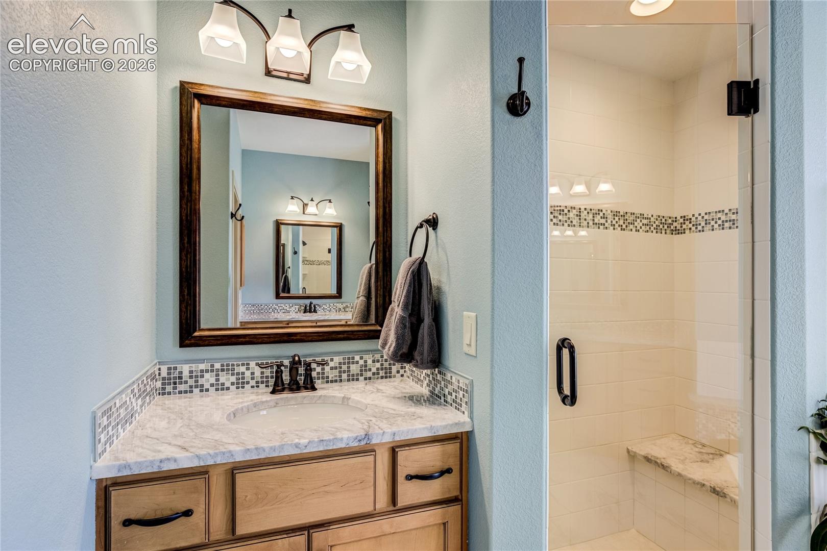 Two granite-topped vanities, custom cabinetry + a separate glass-enclosed shower combine refined finishes with exceptional everyday convenience.