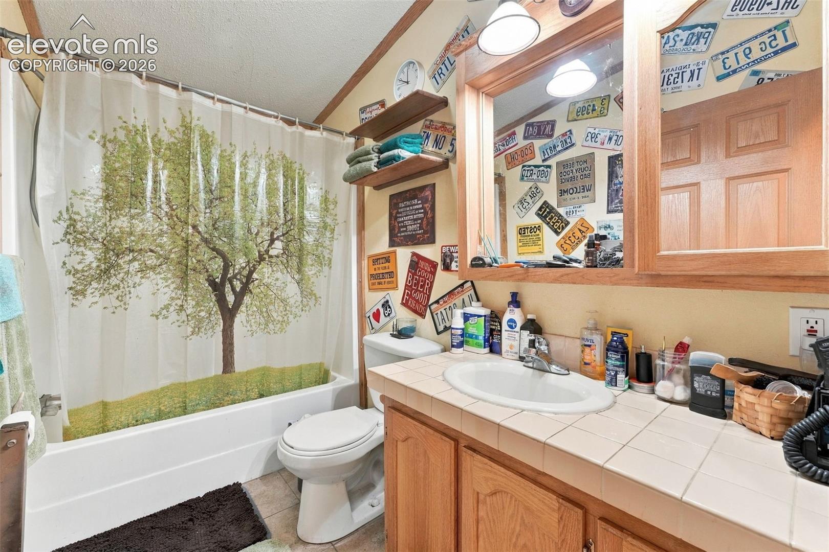 Bathroom featuring a tile-surround bathtub, wood-finish cabinetry, a ceramic drop-in sink, and a built-in recessed mirror medicine cabinet