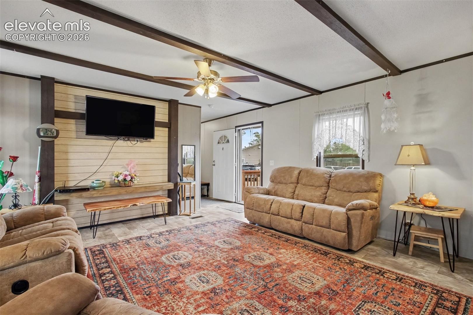 2nd Home: Cozy living room featuring a stylish accent wall, exposed beams, and a perfect setup for enjoying the TV while relaxing or entertaining.