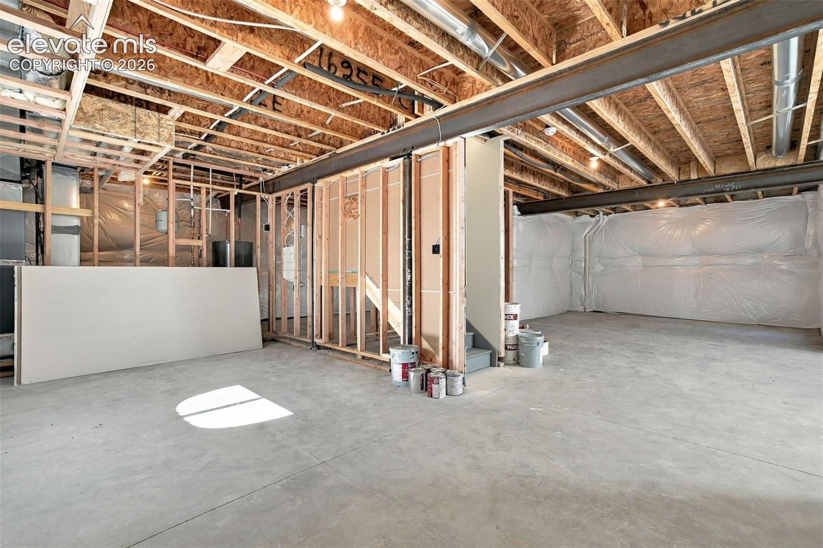 Unfinished basement with exposed ceiling joists, and concrete flooring