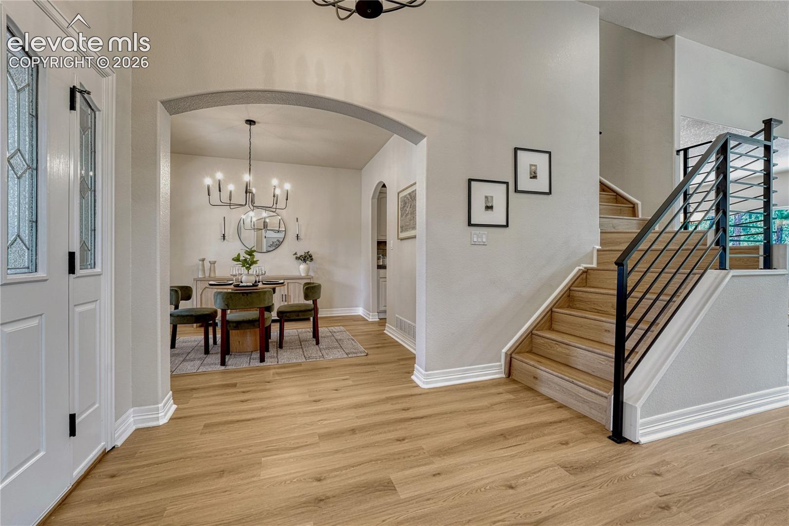 New metal stair rail and arched entries to the formal dining room.