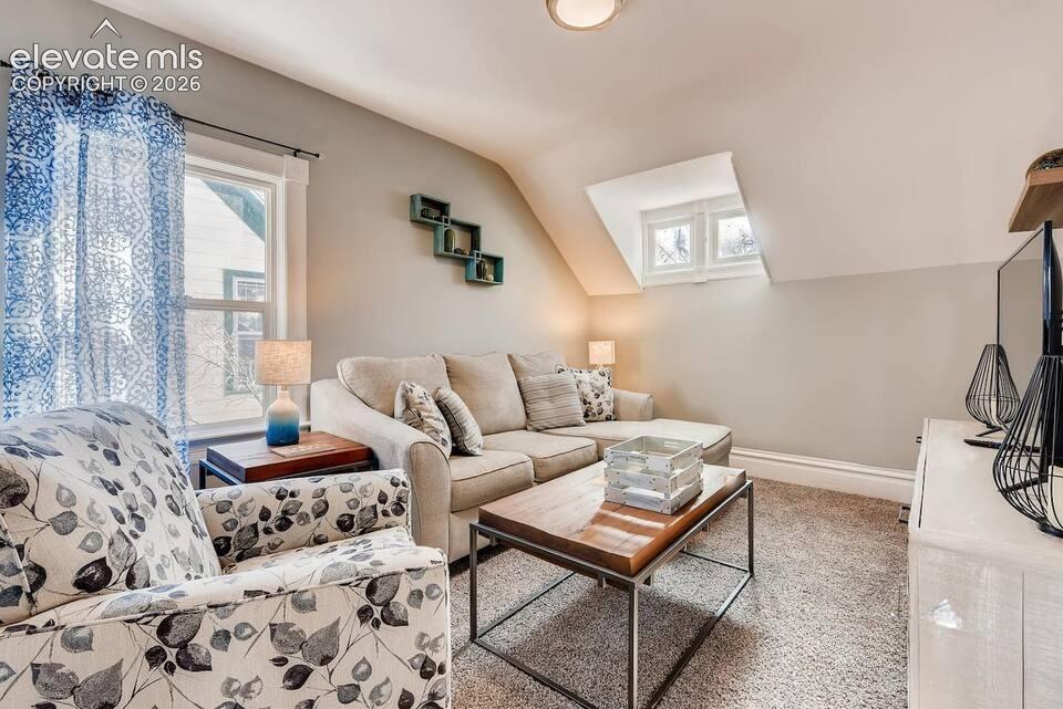 Second floor living room or bedroom with fun slanted ceiling and dormer window.
