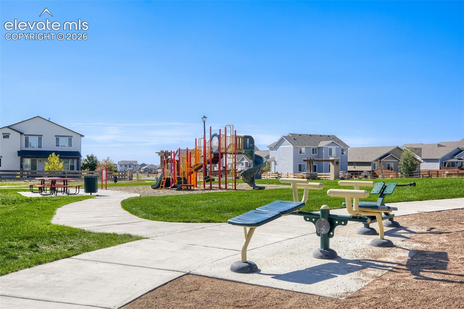 Community green space featuring a playground and concrete pathways