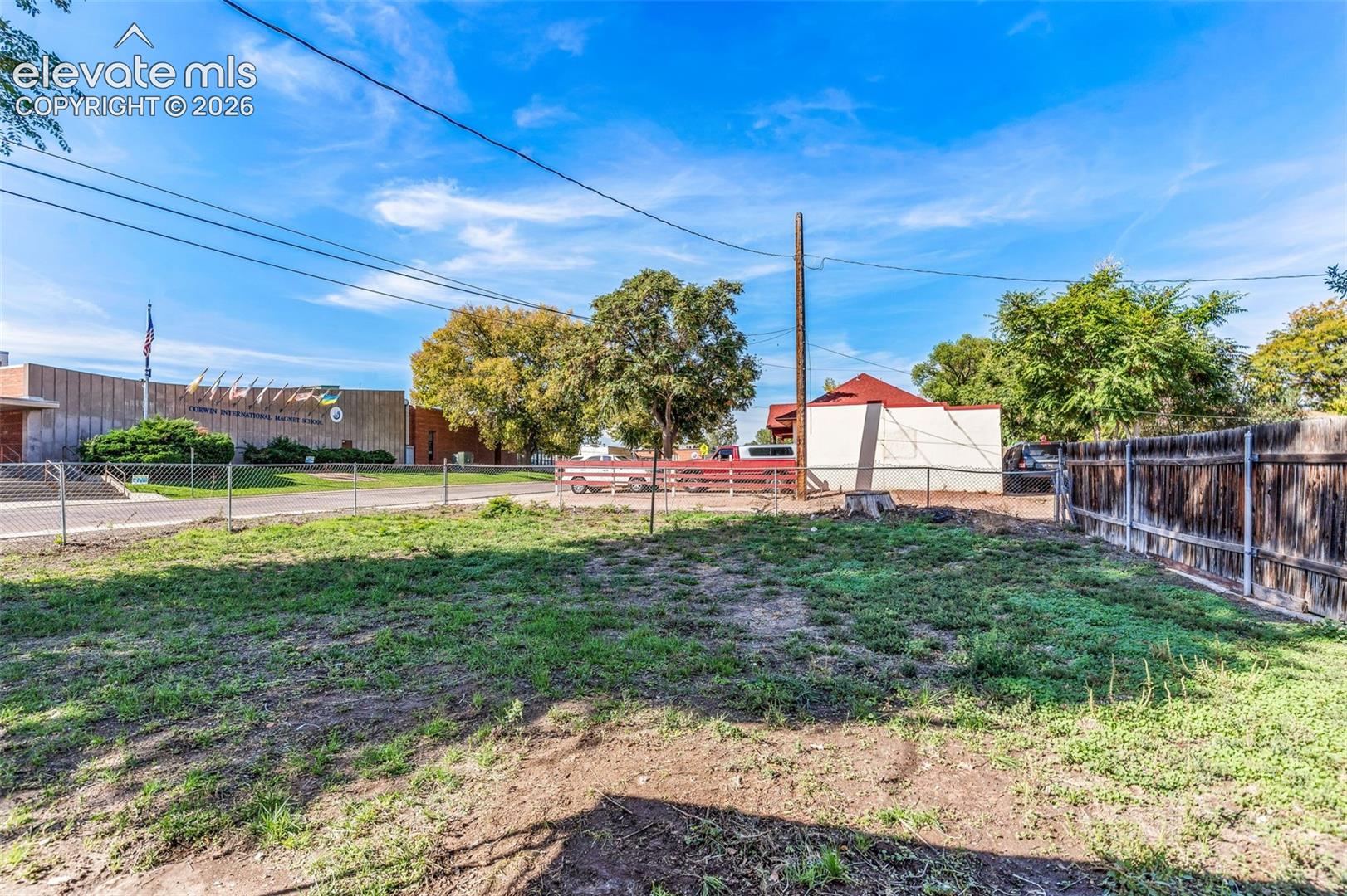 Open-air yard space featuring a perimeter chain-link fence and a vertical wood privacy screen