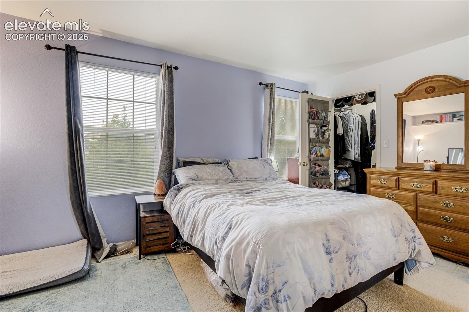 Dual windows with horizontal blinds, providing natural light
