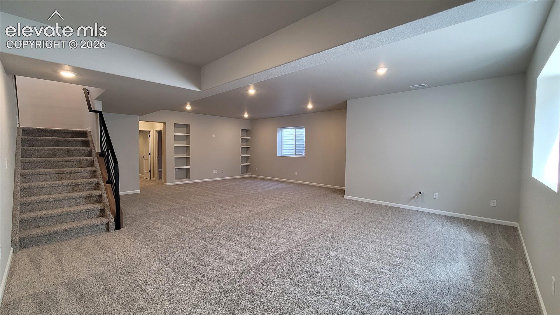 Finished Basement with 9' Ceilings boasts a spacious family room with built-in shelving and game area prepped for a future wet bar! 