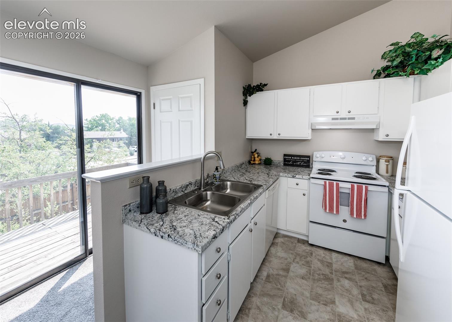 Kitchen featuring white cabinetry, a dual basin stainless steel sink, light-toned granite-style countertops, and a full-size electric range
