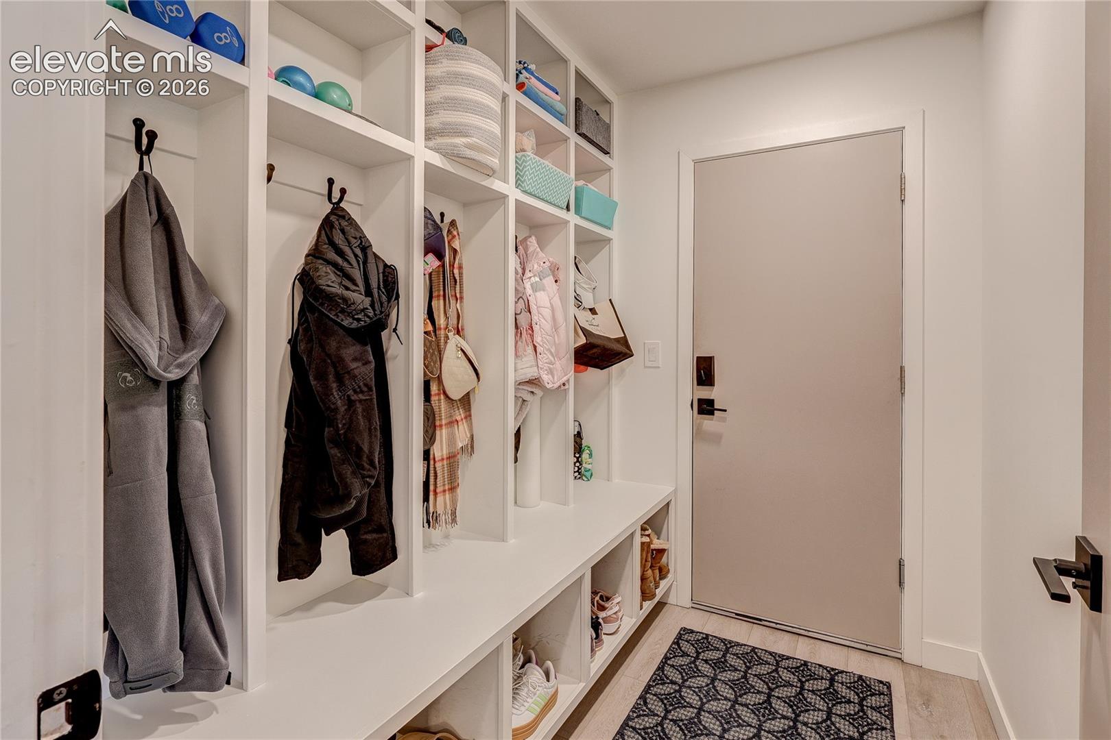 Built-in mudroom storage with integrated shelving, hooks, and bench seating