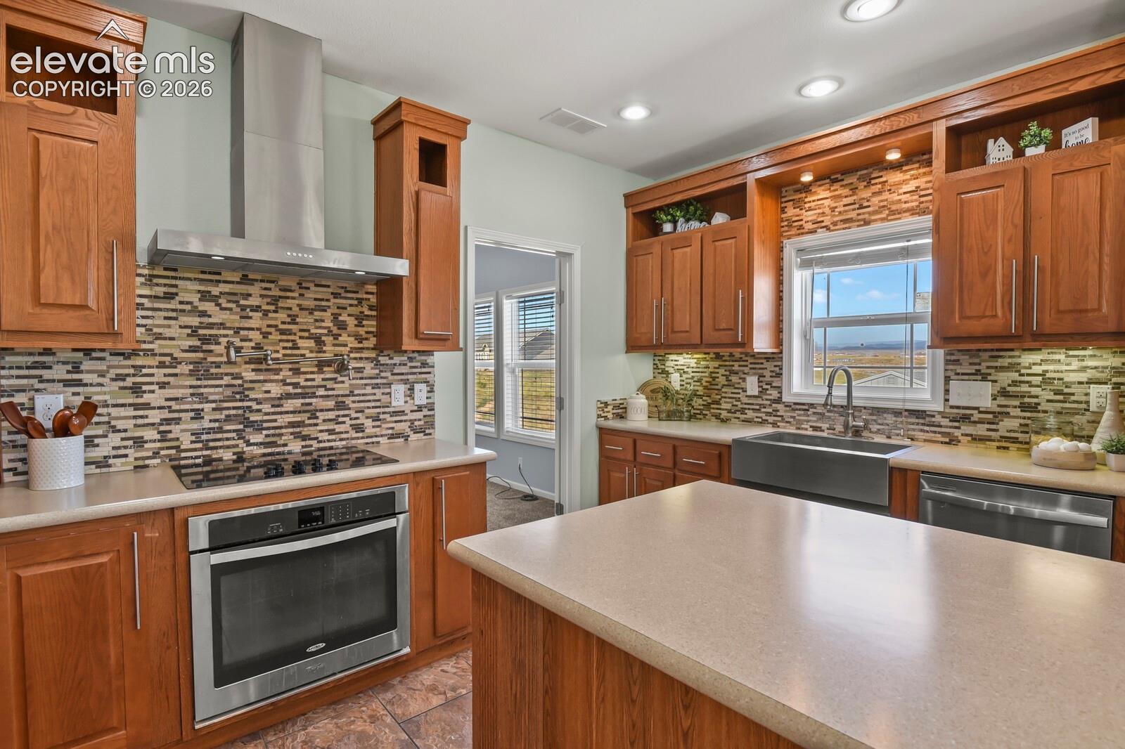 The kitchen features a hood vent, cook top, and pot filler. 